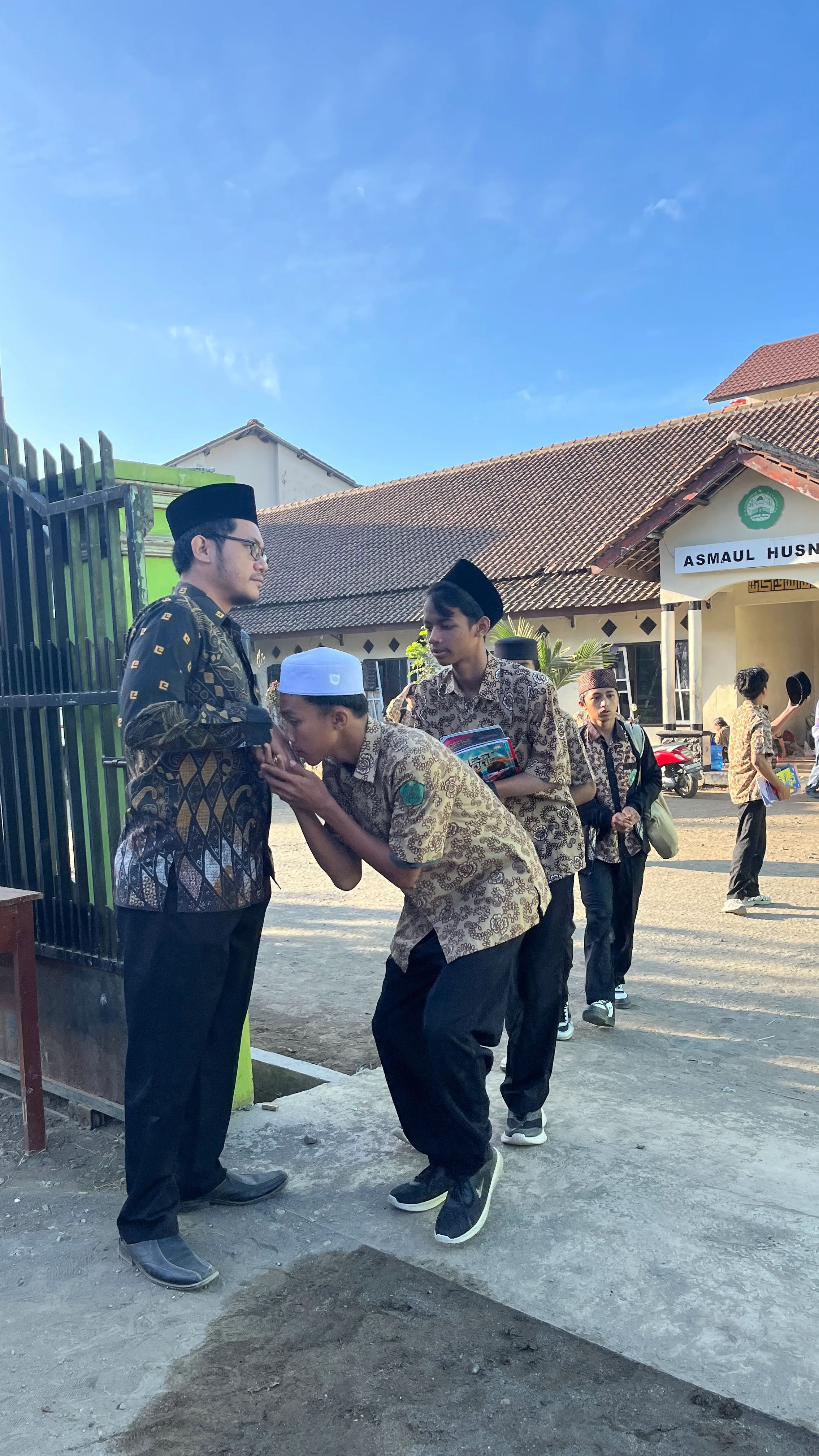 Kepala madrasah dan guru menyambut siswa yang tiba di MA MINAT